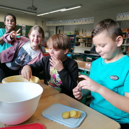 Vier Kinder lassen sich das Gekochte schmecken.