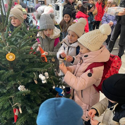 Kinder schmücken den Weihnachtsbaum.