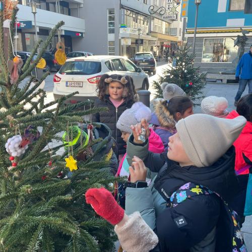 Kinder schmücken den Weihnachtsbaum.