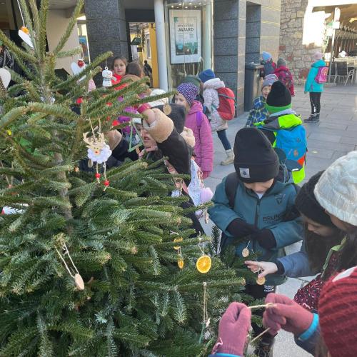 Kinder schmücken den Weihnachtsbaum.