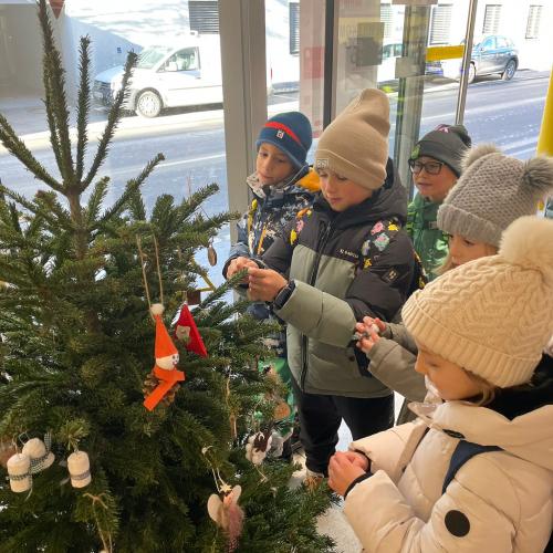 Kinder schmücken den Weihnachtsbaum.