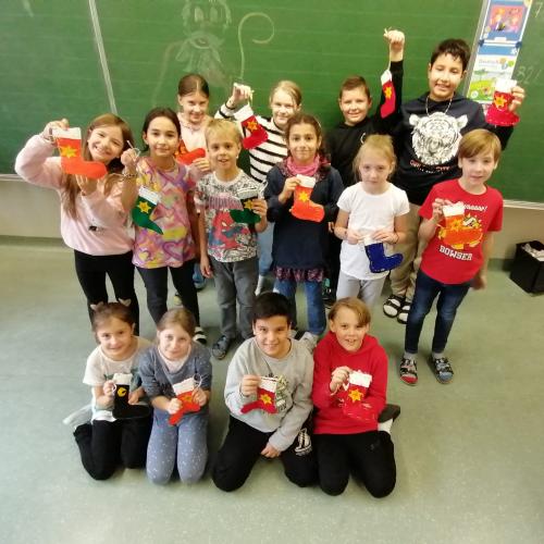 Kinder zeigen ihre selbstgenähten Nikolaussocken