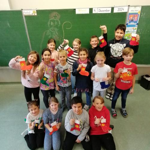 Kinder zeigen ihre selbstgenähten Nikolaussocken