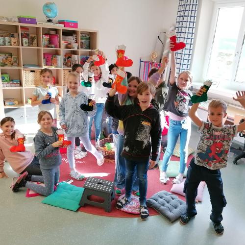 Kinder zeigen ihre Nikolaussocken, welche mit Süßigkeiten gefüllt sind