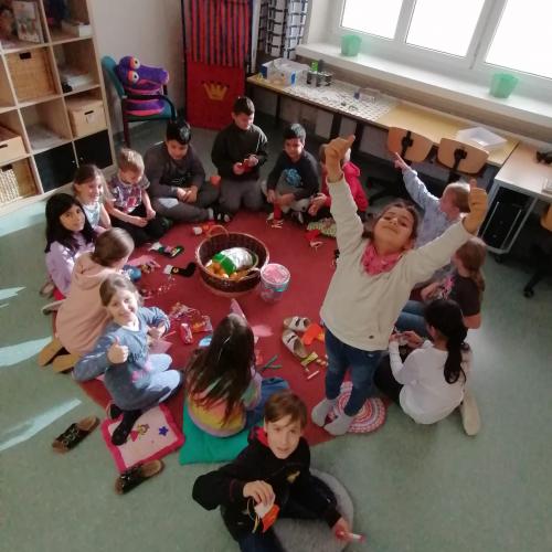 Kinder sitzen auf einem runden Teppich und feiern Nikolaus