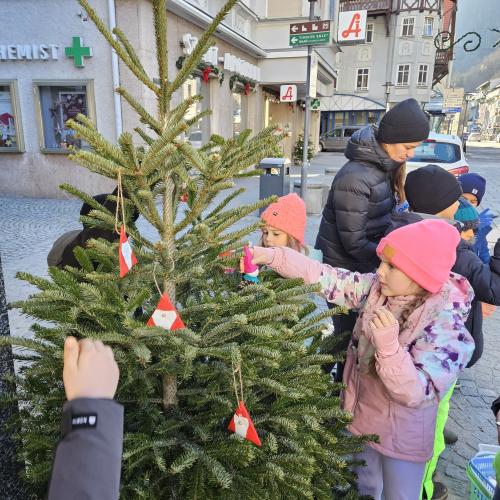 Kinder schmücken den Weihnachtsbaum.