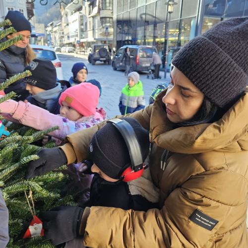 Kinder schmücken den Weihnachtsbaum.