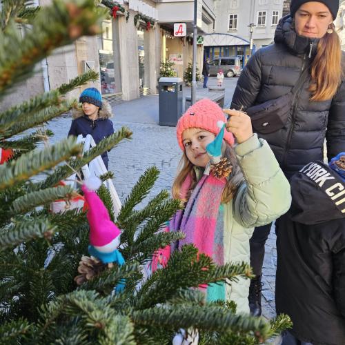 Kinder schmücken den Weihnachtsbaum.