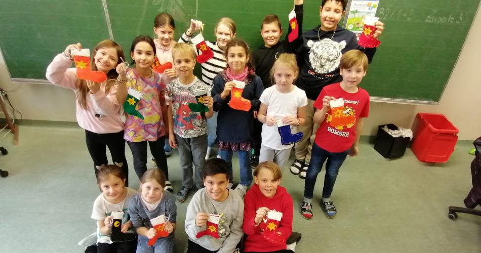 Kinder zeigen ihre selbstgenähten Nikolaussocken